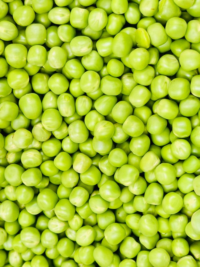 our-stories A detailed close-up shot of fresh green peas showing their vibrant color and texture.